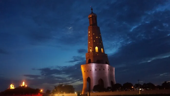 Fateh Burj victory tower at Chappar Chiri near Mohali, lit up against a deep blue evening sky