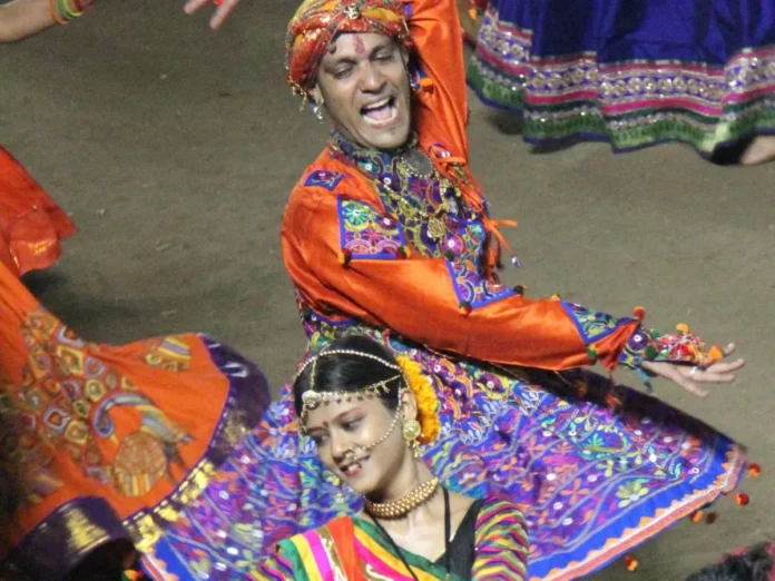 A man and a woman in traditional Gujarati dress dancing Garba during Navratri in Vadodara, Gujarat