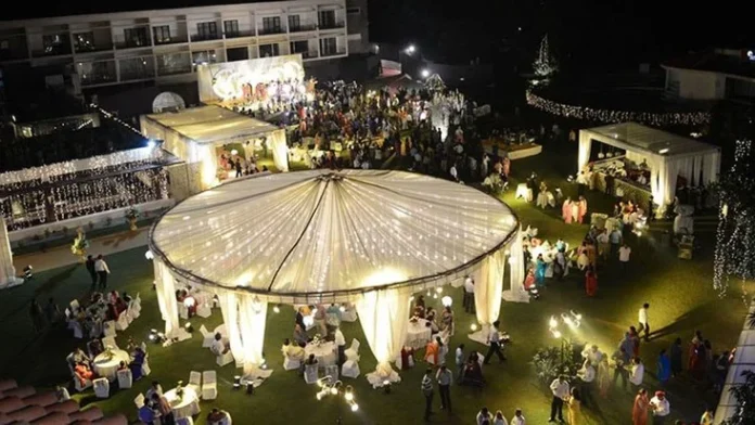 Evening event on the lawns of Hotel Mountview, Chandigarh, with lit white pavilions, a stage and guests