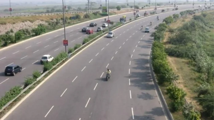 A wide multi-lane highway with light car and scooter traffic