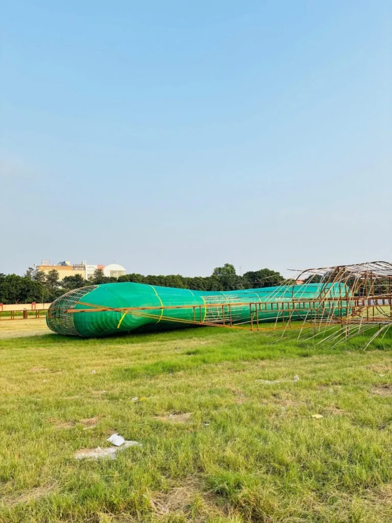 Steel and bamboo frame of a Ravan effigy under construction on open ground, photographed in September 2025