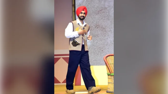 Diljit Dosanjh in an orange turban and checked jacket at a film trailer launch in 2024